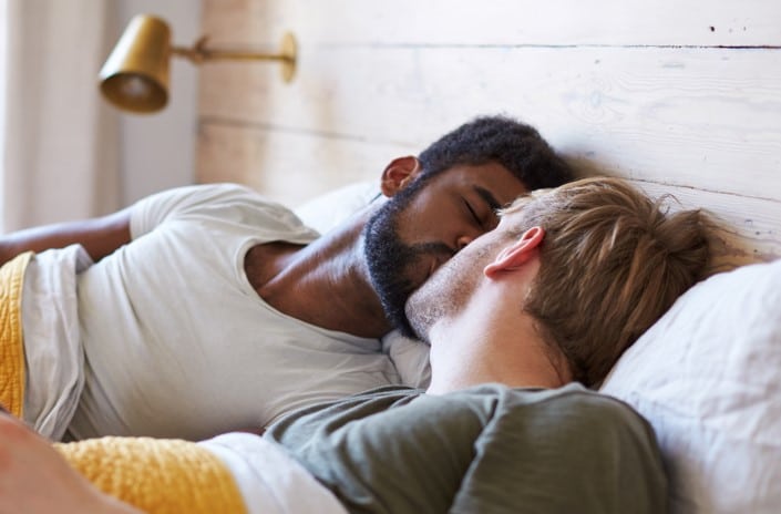 romance gay multiraciale avec deux hommes dans un lit qui s'aiment